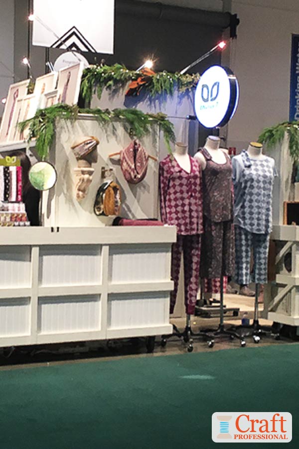 Three mannequins in a row displaying handmade pajamas in a craft booth demonstrate the display concept of arranging items in odd numbered groups.