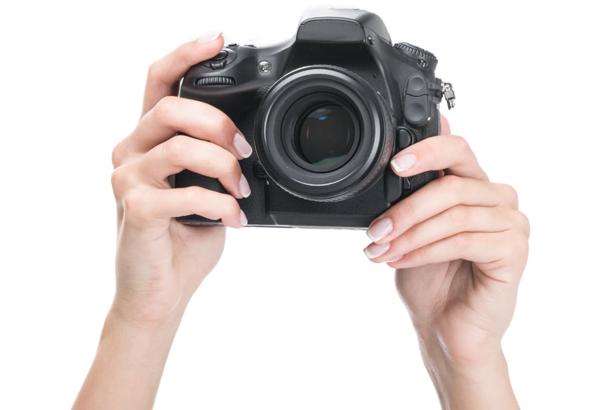 Woman's hands holding DSLR camera Woman's hands holding DSLR camera