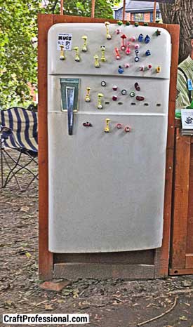 Handmade magnets displayed on a refrigerator door at an outdoor craft show. Handmade magnets displayed on a refrigerator door at an outdoor craft show.