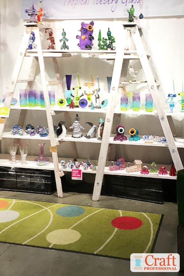 Handmade pottery displayed on ladder style shelves.