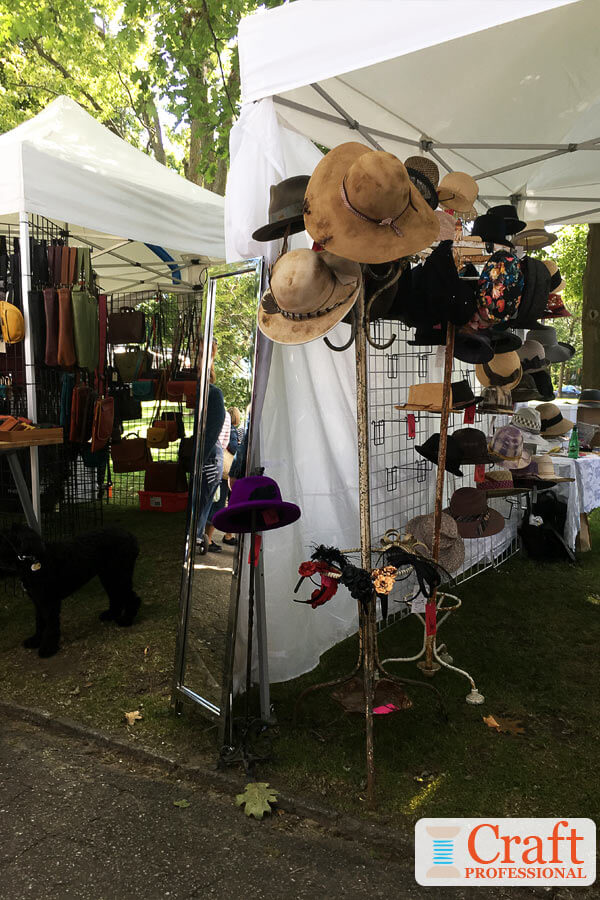 Handmade hats displayed on a millinery tree at an outdoor craft show. Handmade hats displayed on a millinery tree at an outdoor craft show.