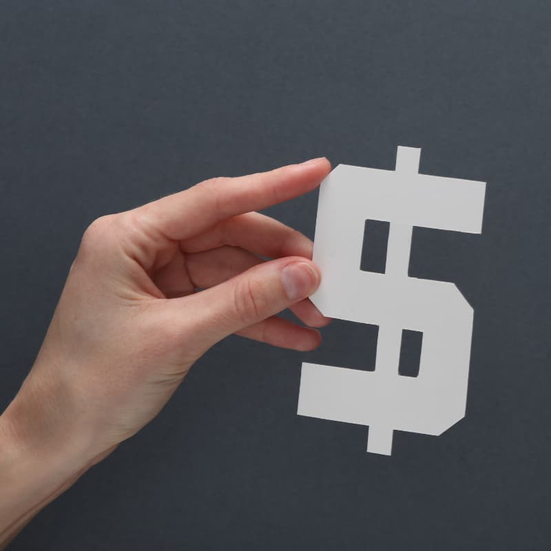 Hand holding paper dollar sign on a black background Hand holding paper dollar sign on a black background