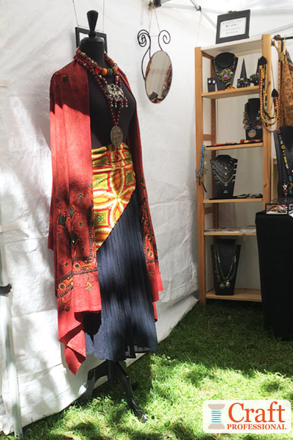Dress form displaying handmade jewelry at the front corner of an outdoor craft booth helps to draw attention from a distance. Dress form displaying handmade jewelry at the front corner of an outdoor craft booth helps to draw attention from a distance.
