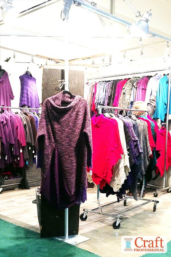 Wheeled clothing racks in a craft booth.