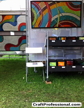 Art displayed on mesh panels at a craft show.