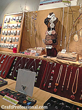 Tabletop jewelry display with necklaces displayed on branches.