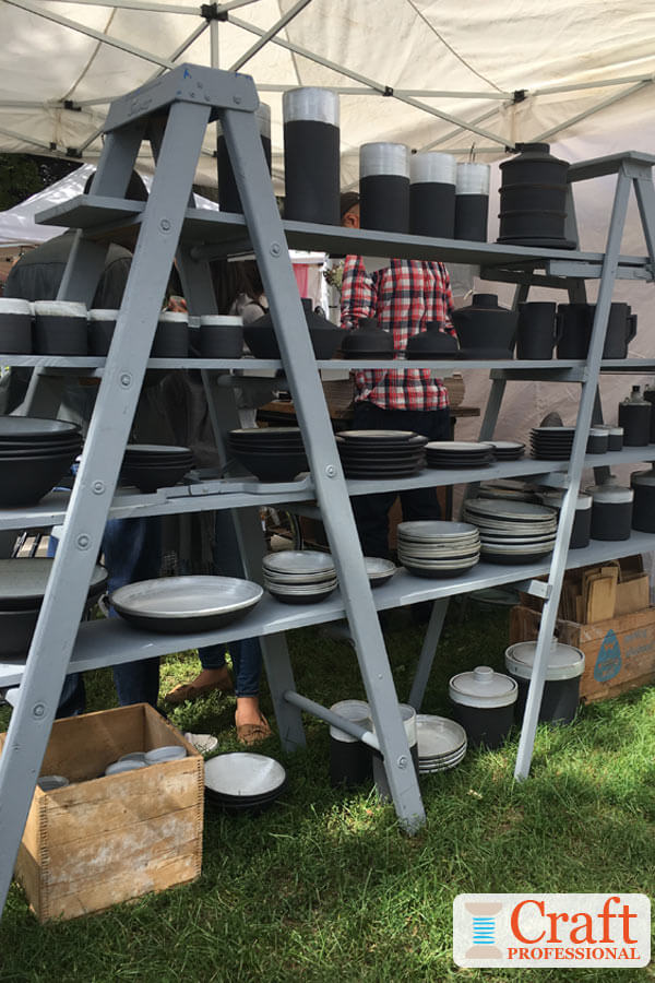 Ladders used as shelf display space at a craft fair.