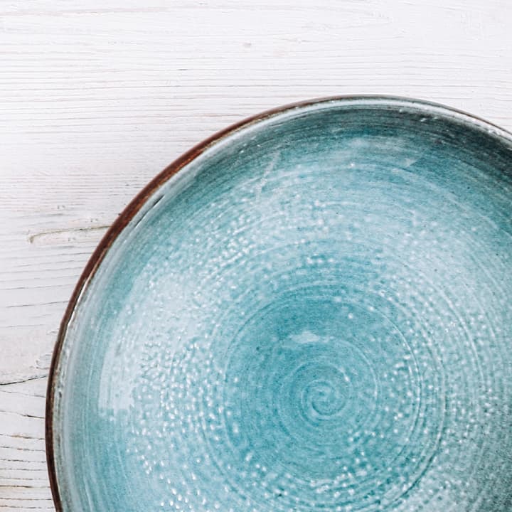 Handmade blue ceramic plate with a glossy glaze and subtle texture, highlighting artisan pottery craftsmanship. Handmade blue ceramic plate with a glossy glaze and subtle texture, highlighting artisan pottery craftsmanship.