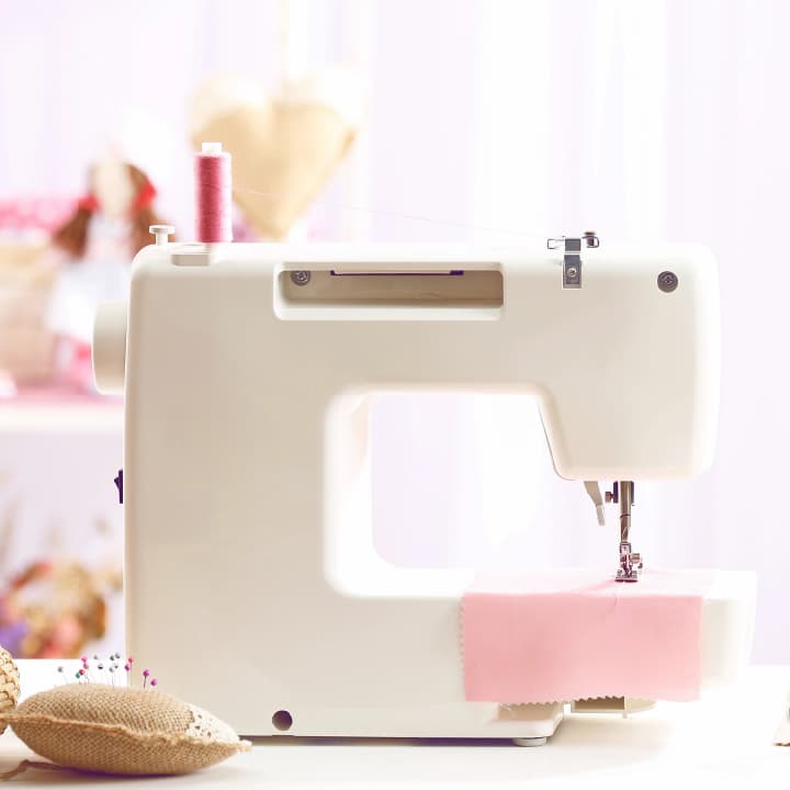 Sewing machine on a craft table, representing the process of making handmade crafts. Sewing machine on a craft table, representing the process of making handmade crafts.