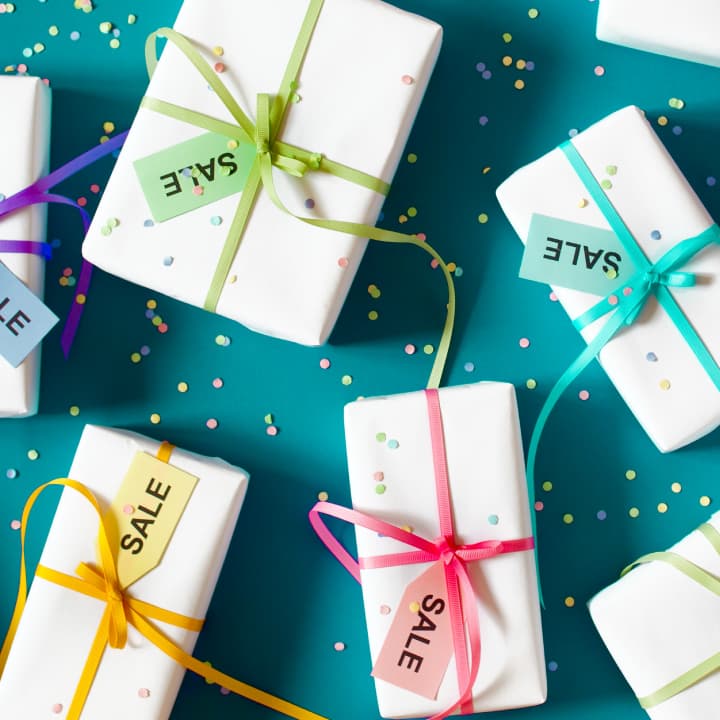 Gift boxes tied with ribbon and marked with sale tags, representing discounted handmade products or holiday craft sales. Gift boxes tied with ribbon and marked with sale tags, representing discounted handmade products or holiday craft sales.