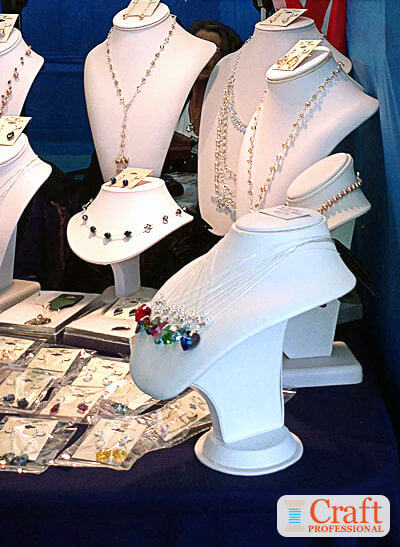 Handmade jewelry displayed on white jewelry busts.