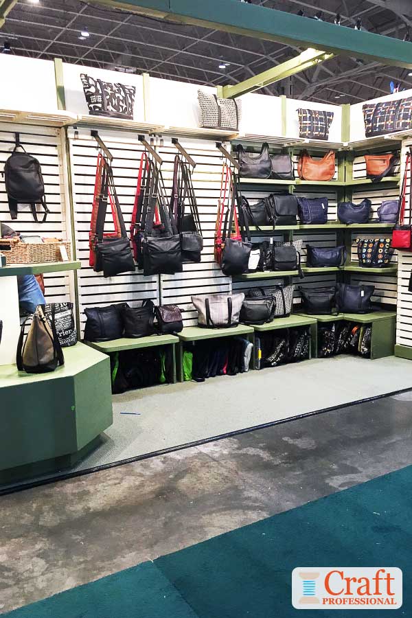 Handbags displayed on slatwalls at a craft show