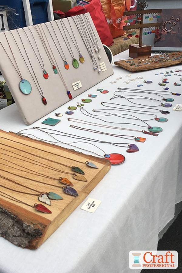 Handmade necklaces on display at an outdoor farmer's market. Handmade necklaces on display at an outdoor farmer's market.