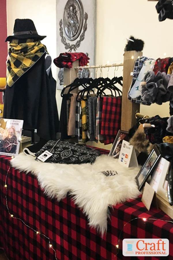 Handmade red and black, and yellow and black buffalo check scarves on a tabletop display at a craft show. Handmade red and black, and yellow and black buffalo check scarves on a tabletop display at a craft show.